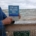 Joan Donaldson holds her copy of On An Inland Sea: Writing the Great Lakes at Pier Cove Park on the Lake Michigan shore.